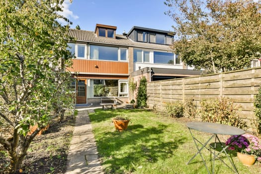 A beautifully landscaped garden featuring a modern house. The yard includes well-maintained plants and outdoor seating for relaxation.