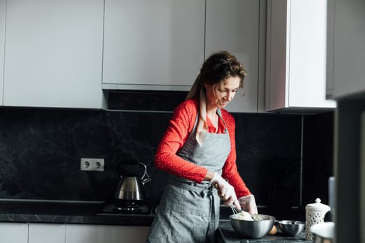 Woman in red dress preparing food in kitchen for dinner