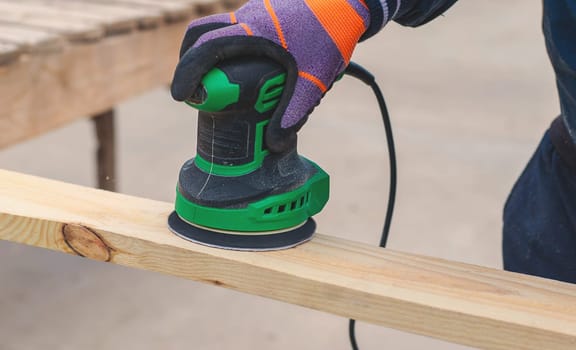 Man sanding wooden boards. Selective focus. People.