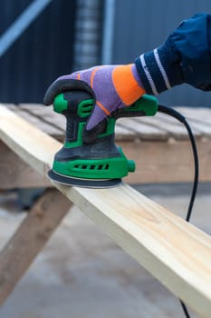 Man sanding wooden boards. Selective focus. People.