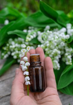 Lily of the valley extract in a bottle. Selective focus. nature.