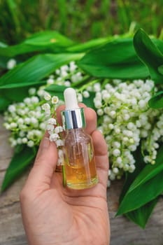 Lily of the valley extract in a bottle. Selective focus. nature.