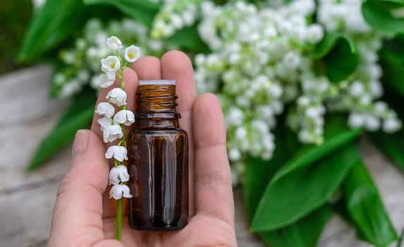 Lily of the valley extract in a bottle. Selective focus. nature.
