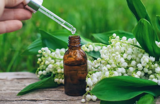 Lily of the valley extract in a bottle. Selective focus. nature.