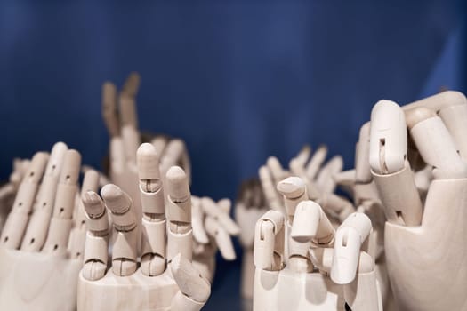 Dummy model wooden human hands gesture set on shelf on blue background close up. Mannequin hand collection closeup. Copy space