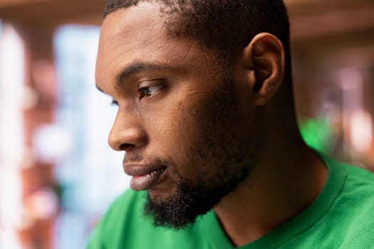 Man having detached apathy facial expression while at home, not caring. Apathetic African american having disinterested indifferent mood while in apartment, close up shot