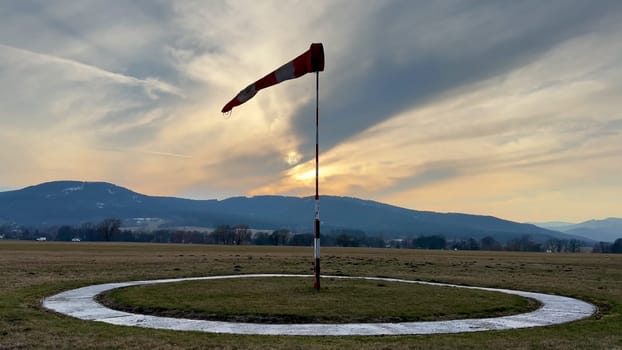 A vibrant windsock stands tall against a picturesque twilight backdrop, symbolizing a passion for aviation