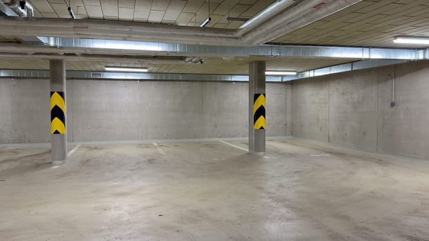 A comprehensive and detailed view of an underground parking garage showcasing ceiling infrastructure and piping systems