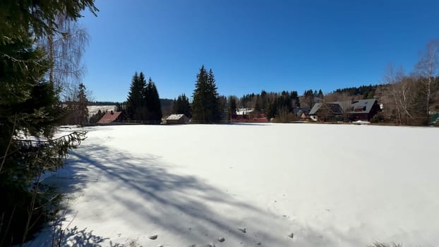 A beautifully tranquil winter scene showcasing a vast, snowcovered field beneath a vibrant, bright blue sky