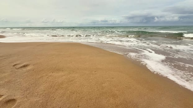 A serene beach scene showcasing calm waves gently lapping at the warm golden shore, inviting relaxation and tranquility