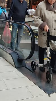 October 22 2024 Hradec Kralove, Czech Republic Europe, Kralov region, Kralovehradecky kraj, Elderly woman escalator. High quality photo editorial people
