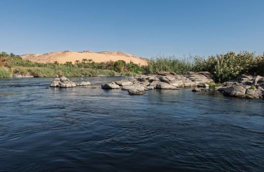 Granite rocks in the fast flowing water of the River Nile near Aswan Egypt