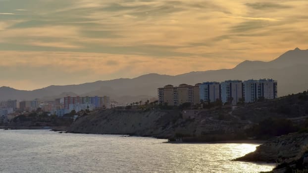 A breathtaking view of the stunning coastline during sunset, showcasing majestic mountains and calm waters