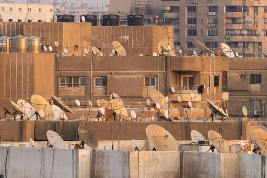 Many satellite dishes crowd the rooftops of apartment buildings in Cairo near the airport