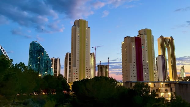 A stunning view of a city skyline at dusk, showcasing beautiful illuminated buildings and vibrant clouds.