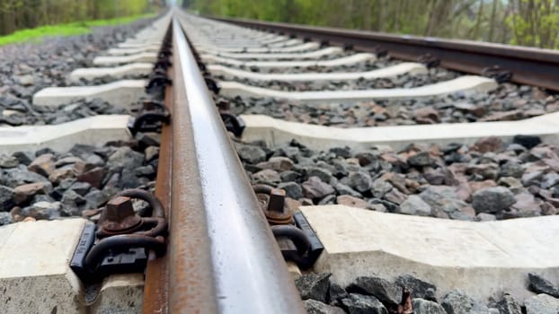 A beautiful and tranquil perspective of railway tracks gracefully set amidst lush greenery and gravel pathways