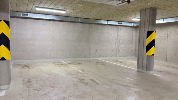 A clean, spacious parking garage with sturdy concrete walls and bold yellowblack safety markings for visibility
