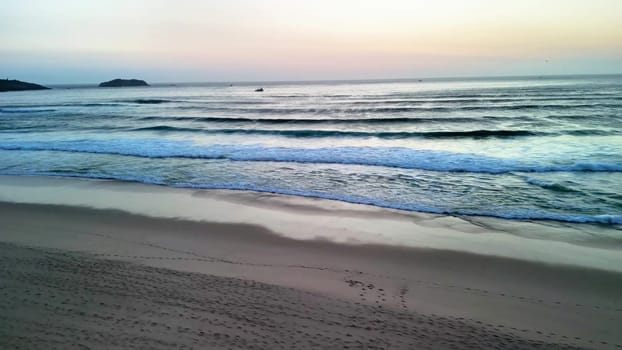 A tranquil view of gentle waves lapping against the shore at sunset, perfect for relaxation and nature themes.