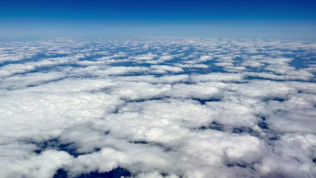 A stunning aerial perspective showcasing an expansive sea of beautiful white clouds under a clear blue sky
