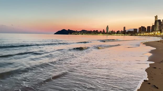 A stunning sunset view of the ocean with an impressive city skyline, perfect for travel or nature themes