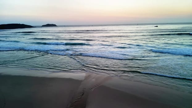 A serene and tranquil beach scene at sunset featuring gentle waves lapping softly against the shore