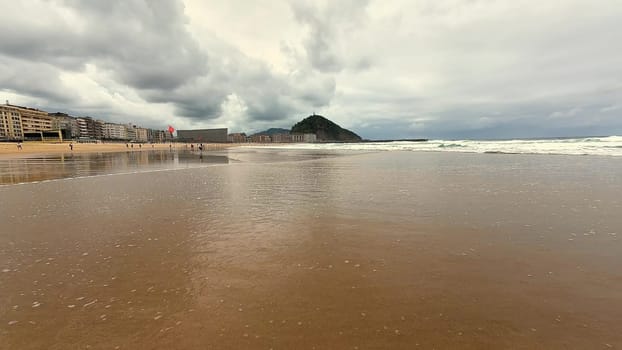 A beautifully serene beach scene featuring gentle waves, a sandy shore, and dramatic, fluffy clouds overhead