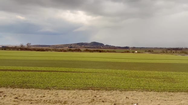 A serene view of green fields under an overcast sky, perfect for appreciating natures beauty and tranquility