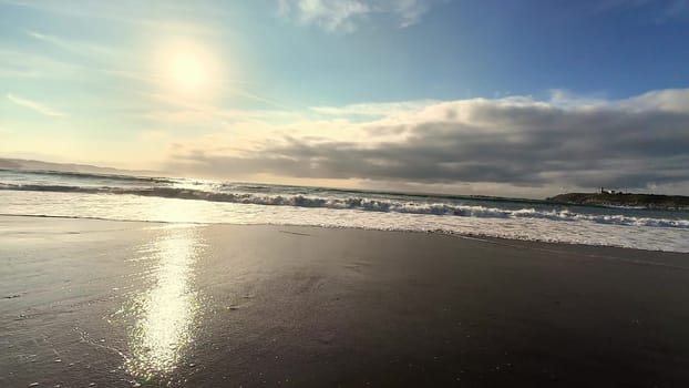 A stunning sunset reflects beautifully on the gentle waves of the beach, showcasing natures incredible beauty