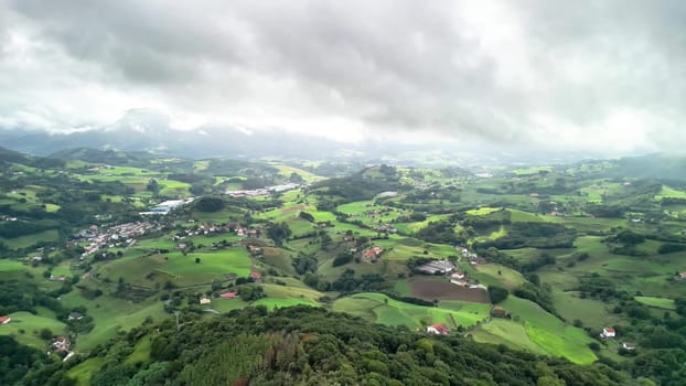 A stunning aerial view of lush green hills under a cloudy sky, showcasing serene landscapes and vast countryside