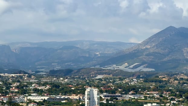 A stunning landscape features majestic mountains above a vibrant city, highlighting natures beauty and diversity
