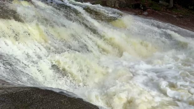 Captivating footage of powerful water cascading gracefully over rocks in a beautiful natural setting