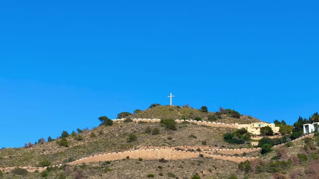 A peaceful and serene hillside that features a prominent cross, embraced by the surrounding nature and tranquility