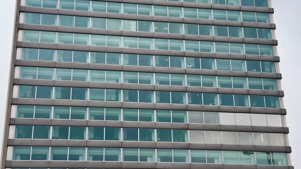 This contemporary office building features a striking, sleek glass exterior with multiple designed floors that impress