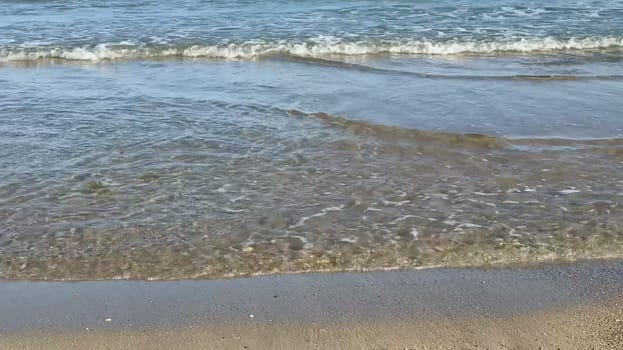 The beautiful ocean waves are gently caressing the soft sandy beach, creating a perfectly tranquil coastal scene