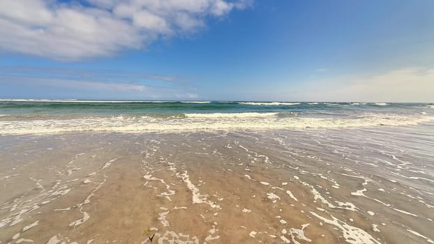 Delight in the soothing tranquility brought by ocean waves gently lapping against the warm, inviting shore