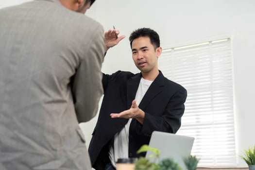 A focused professional presents ideas and concepts to a colleague, fostering a collaborative environment in a sleek office space.