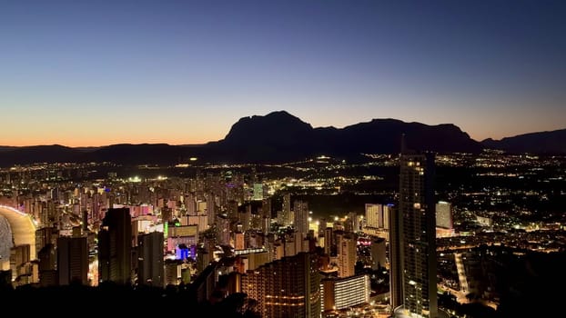 A breathtaking urban city skyline, beautifully illuminated at night, set against a vibrant dusk sky full of colors