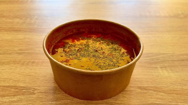 A vibrant and colorful bowl of aromatic spiced soup, meticulously garnished beautifully for an appealing presentation
