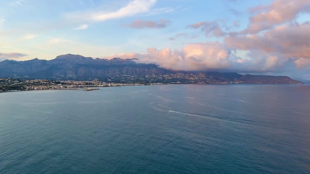 A stunningly beautiful coastal view at sunrise, showcasing magnificent mountains and calm, tranquil waters