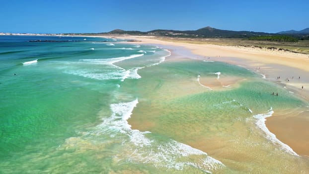 A breathtaking aerial shot showcasing a tranquil beach with crystalclear waters and gentle waves at the shore