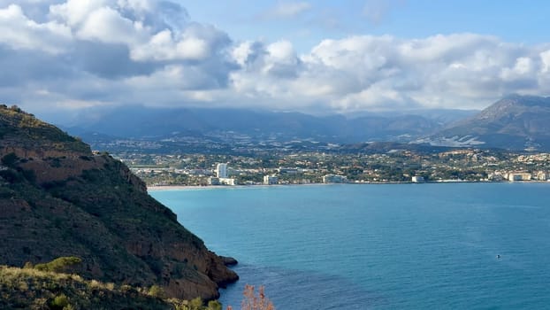 A breathtaking coastal view that beautifully showcases serene waters, lush green hills, and a captivating skyline
