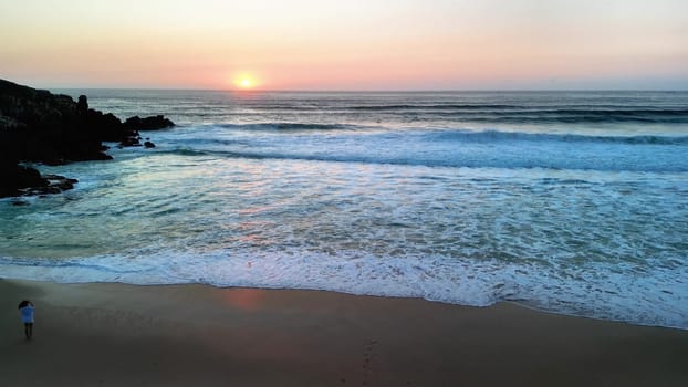 A stunning view of the sunset beautifully reflecting on the calm waves of a tranquil and quiet beach