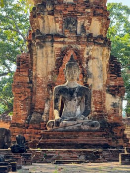 Ancient Buddha statues sitting peacefully in a sacred temple complex, Wat Maha That landmark representing faith and spirituality. Beautiful culture religious destination in Thailand.