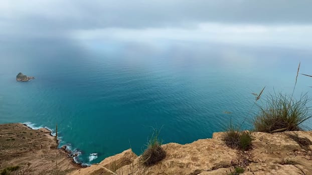 The breathtaking view of cliffs meeting a calm sea beneath beautiful skies is perfect for nature lovers and hikers