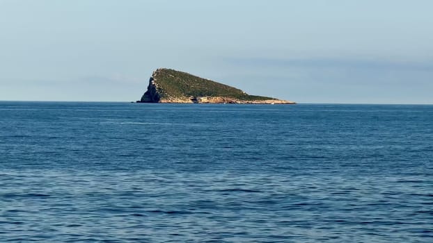 A tranquil island emerges from the clear blue waters, perfect for nature lovers and landscape photography.