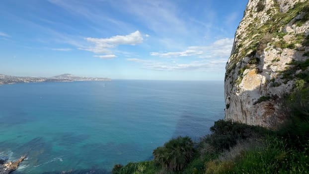 A breathtaking and mesmerizing panoramic view of the calm, peaceful sea and coastal city beneath a clear blue sky