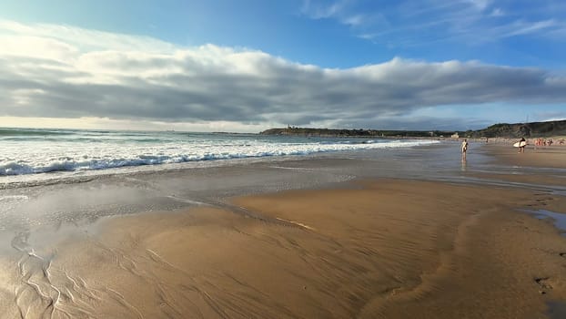 Sandy beach on the ocean shore. Surfing on powerful ocean waves. High quality 4k footage