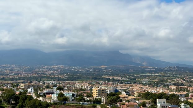 A breathtaking aerial view showcasing a coastal landscape with magnificent mountains and fluffy clouds