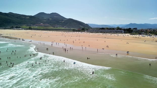 A vibrant beach scene showcasing sunbathers and surfers joyfully enjoying a sunny day beside the ocean waves