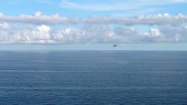 A serene and tranquil ocean landscape showcasing fluffy clouds and a vessel skillfully navigating the vast horizon